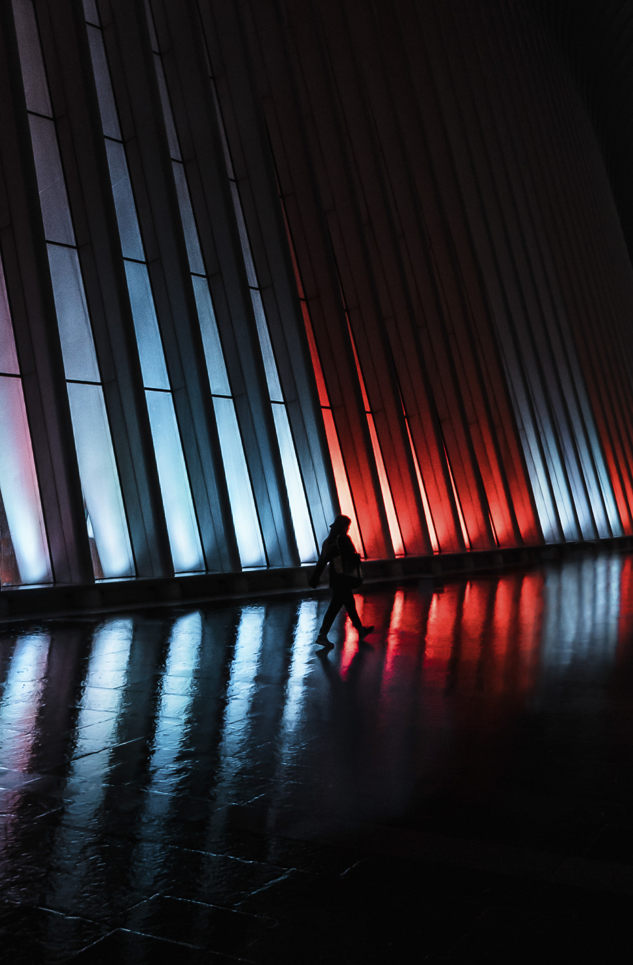 A person walks through a large and dimly lit space